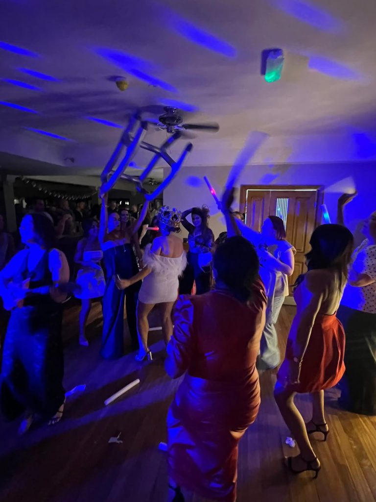 Birthday party guests dancing under blue lighting