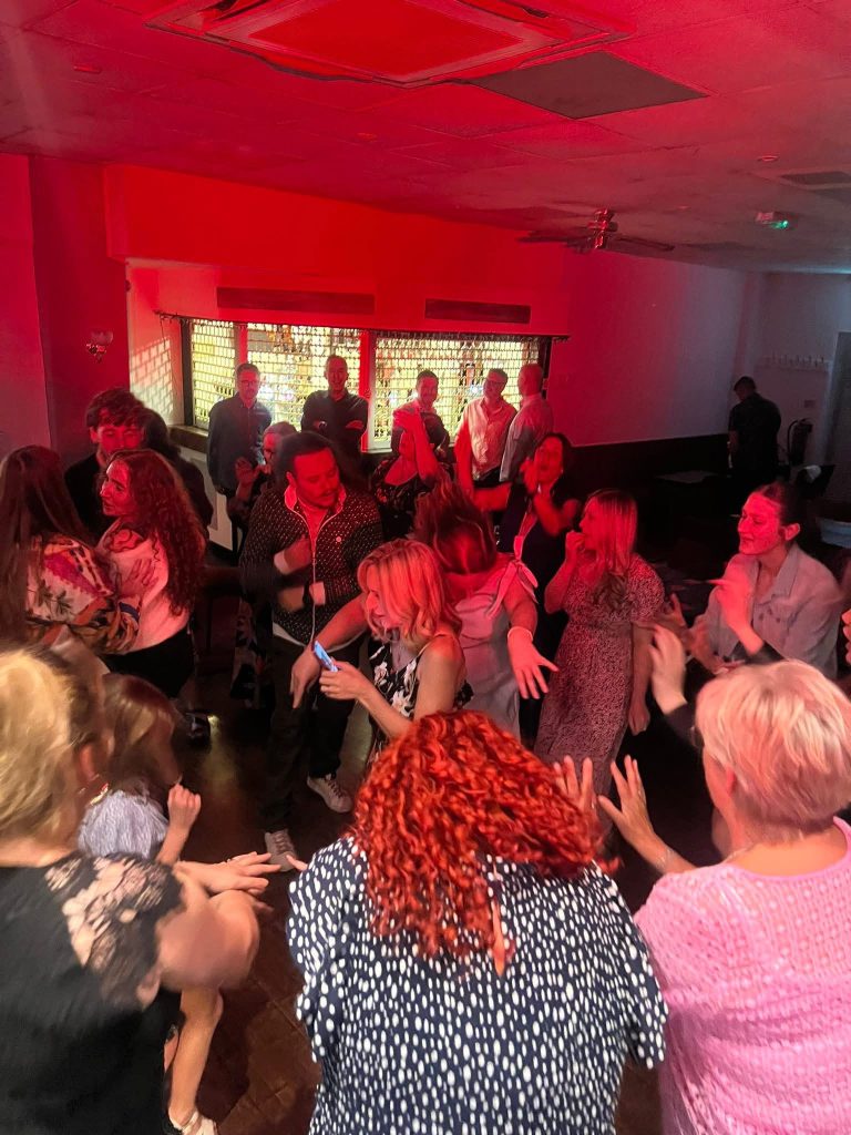 Busy dance floor bathed in red light at a birthday party